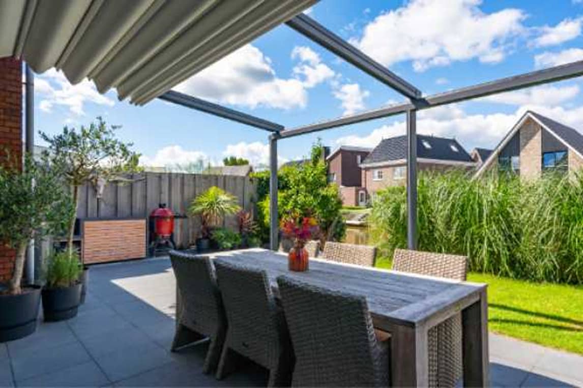 Table and chairs under a veranda with folding roof