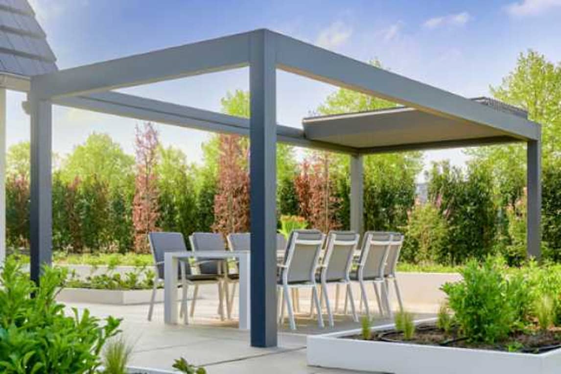 Table and chairs under a pergola with louvered roof
